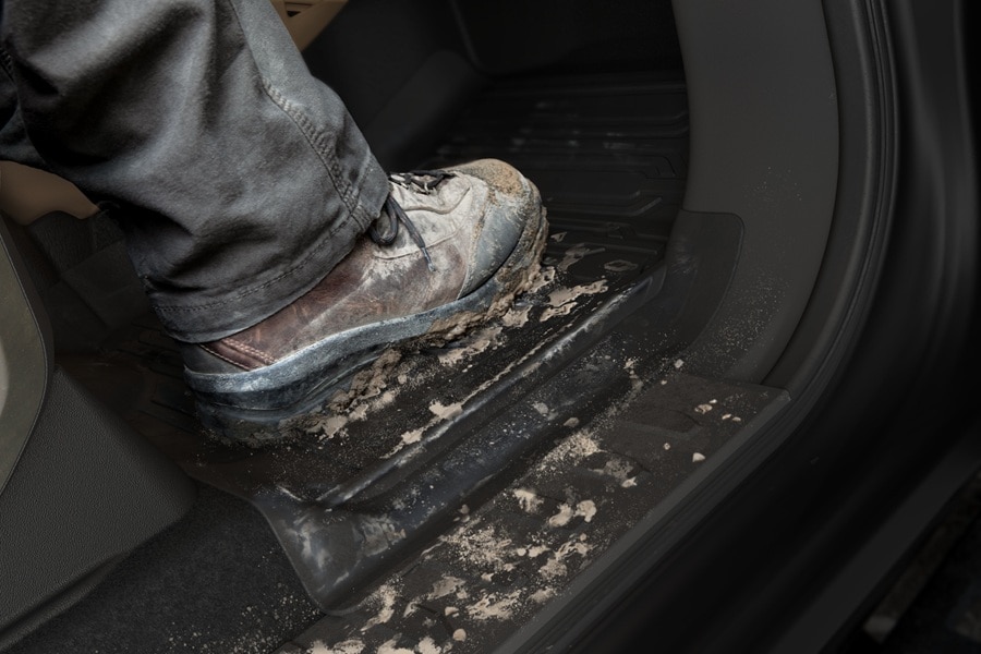 Primer plano de una bota con lodo sobre el tapete resistente de Ford Super Duty Chasis.